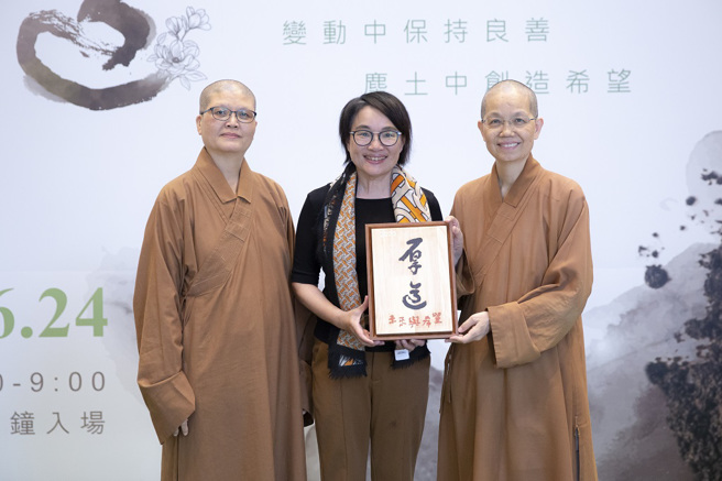 惠中寺住持觉居法师（右）赠送[厚道]结缘品给王文静（中）后与佛光山兰阳仁爱之家执行长妙志法师（左）一同合影。（图／惠中寺提供）