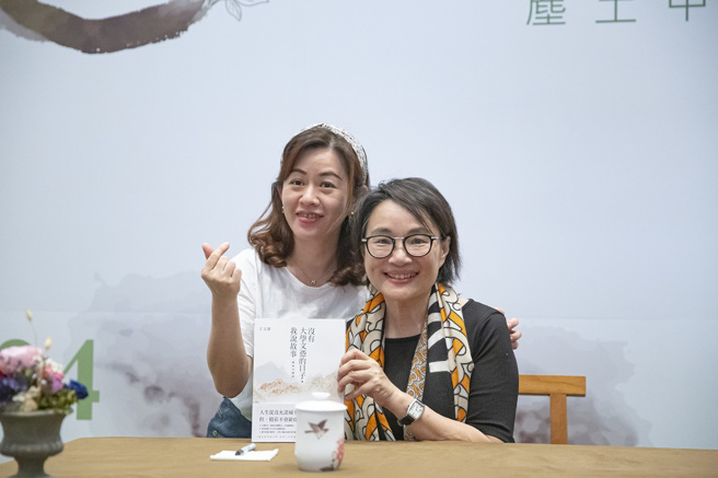 王文静在签书会上帮粉丝马佩诗于新书上签名并开心合影。（图／惠中寺提供）