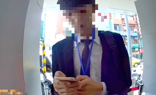 北市一名妇人，日前在信义区庄敬路上一间银行旁，与一名投资顾问公司专员的年轻男子交谈，当杨妇准备交付50万元时，恰巧巡逻员警眼尖发现，上前阻止妇人交款，并查出该名投资专员竟是通缉犯。（翻摄影片）