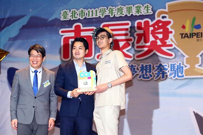 台北市長蔣萬安（中）11日出席111學年度畢業生市長獎頒獎典禮，並逐一頒獎給獲得市長獎的學生，蔣萬安看到建國中學一名戴帽子領獎的學生，神情顯得相當開心。（鄧博仁攝）