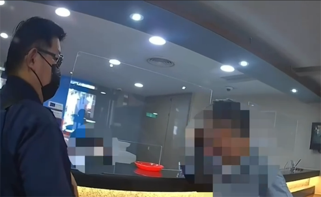 警方在旁不停苦劝，要邱男考虑清楚再匯款。（翻摄照片／高雄洪靖宜传真）