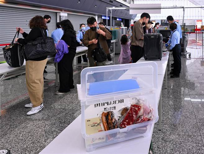 目前入境旅客只要来自非疫区，下机时就可以拿到绿色识别卡片，可免检查随身行李入境，没有拿到绿色卡片的，都要检查随身手提行李，只要旅客检查之前自动通知，或是在通过海关前丢弃到弃置桶，就不会被裁罚。（陈麒全摄）