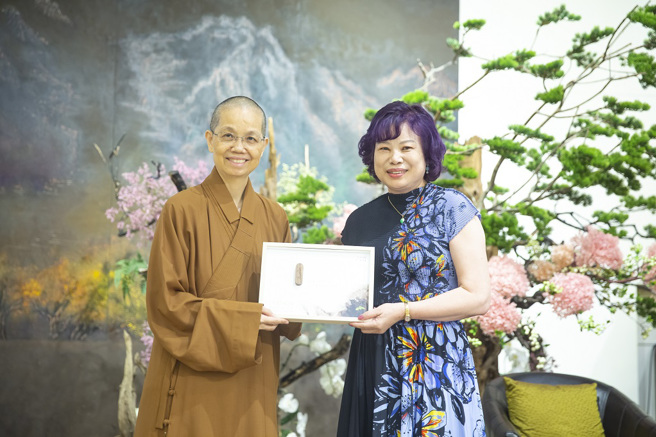 佛光山中區總住持覺居法師（左）致贈獎座及結緣品給黃秀蘭律師（右）。（圖／惠中寺提供）