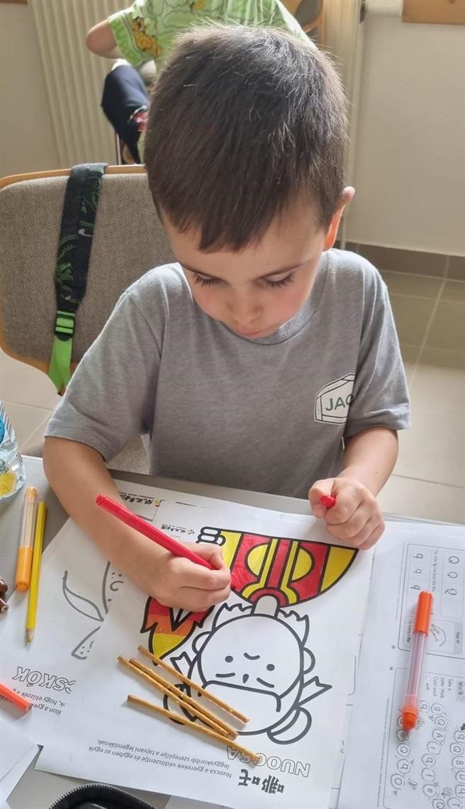 紙風車劇團將於下周在匈牙利布達佩斯演出，本周起也有不少活動在當地開跑。圖為當地因戰爭而流離失所的烏克蘭兒童塗鴉，上色的圖案是台灣兒童守護神「哪吒」。（Litera 協會提供）