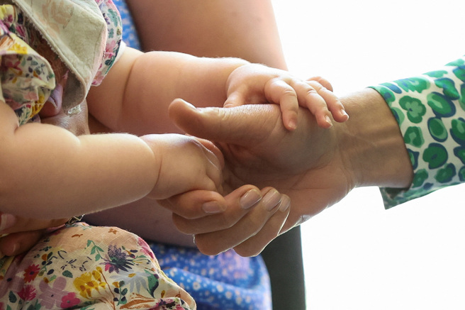 凯特王妃让9个月大的小女娃握着她的手。（路透）