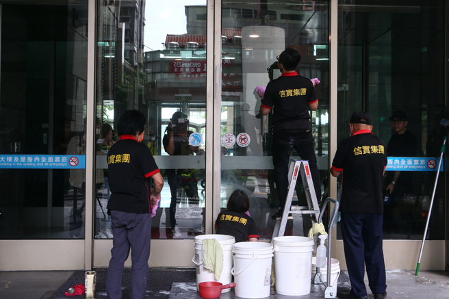 新北市政府16日上午遭不明人士泼漆，1名年约30至40岁男子带着一桶白色油漆至新北市政府南大门，对着门口泼漆后，即刻骑车逃跑，警方目前正积极追缉中，随即清洁公司于现场清理。（邓博仁摄）