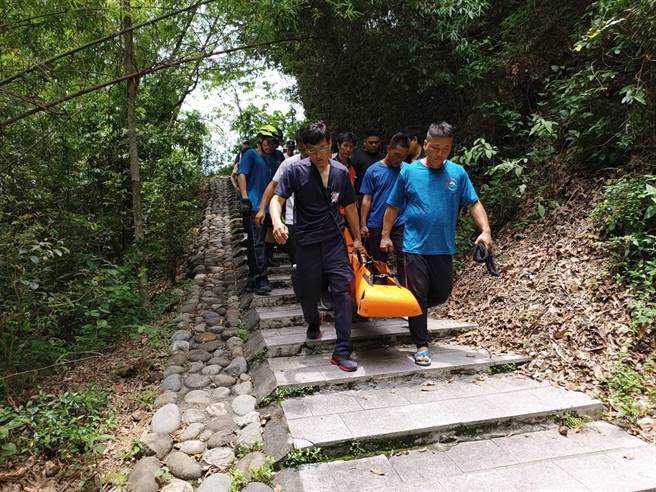 警消将伤者搬运下山，协助送医。(屏县消防局提供)