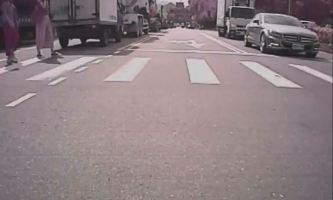 然而，从驾驶的后方行车纪录器可见，有2女子闯红灯走在斑马线上，正好被小货车后柜挡住视线。（翻摄自脸书爆料公社）