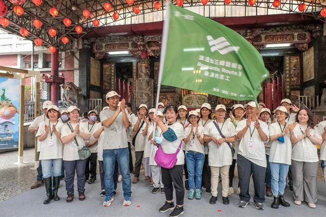 客委会副主委周江杰（左三）为浪漫台3线艺术季3个展区志工授旗，志工代表挥舞大旗，象徵志工全力以赴参与这场客庄夏季盛典。（罗浚滨摄）