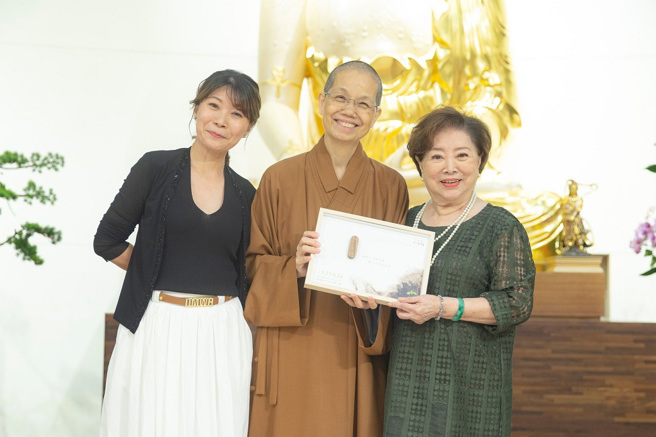 惠中寺住持覺居法師（中）贈送結緣品給陳淑芳（右）後與佛光山均頭中小學表演藝術老師鄒曉雲（右）一同合影。（圖／惠中寺提供）