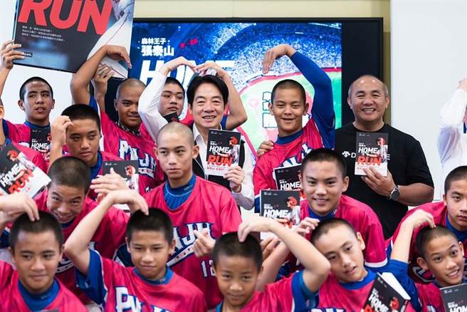 副总统赖清德与张泰山同台赠书，开心和小球迷们合照。（总统府提供）