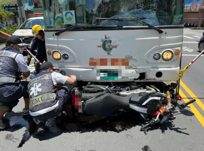 高雄市岡山區岡山路段上今天中午發生一起公車與大型重機車碰撞的交通事故，造成重機騎士連人帶車卡在公車底盤下。（高雄市警方提供／林雅惠傳真）