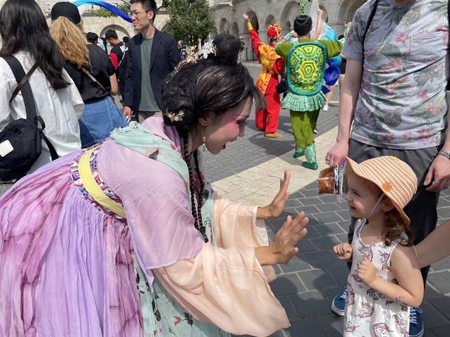 纸风车剧团于匈牙利时间6月17日在当地快闪演出，和当地小朋友开心互动。（纸风车剧团提供）