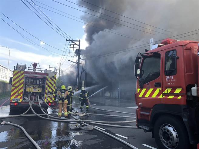 高雄纸扎仓库失火，火苗窜出、浓烟笼罩。（翻摄照片／崔正纲高雄传真）