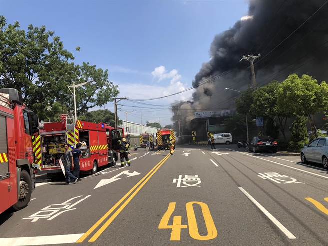 高雄纸扎仓库失火，火苗窜出、浓烟笼罩。（翻摄照片／崔正纲高雄传真）