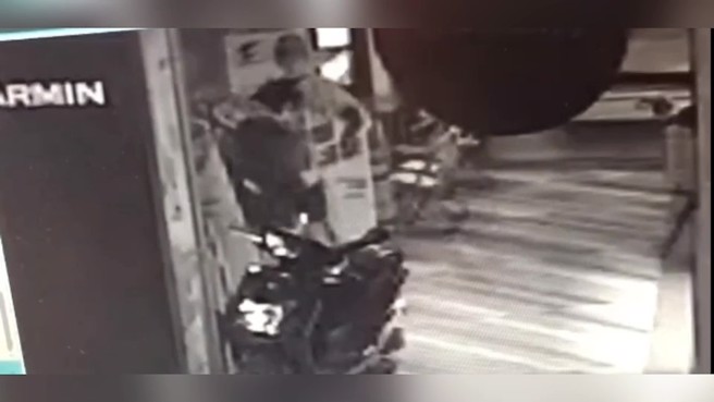 一辆停放在骑楼的机车，徒手深入车厢取走皮夹，并持皮夹内金融卡盗刷500元。（翻摄画面）