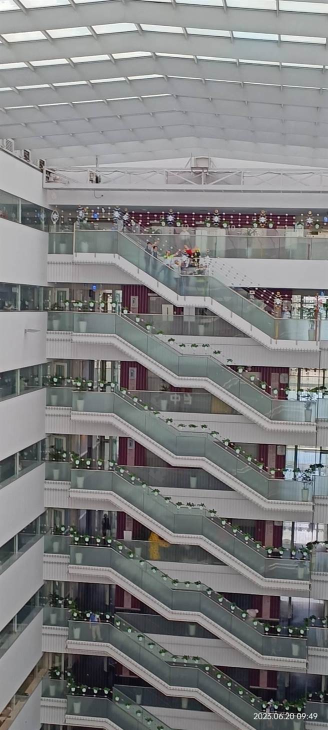 今天上午近10點有名身著紅衣的女子坐在文心樓10樓到9樓的樓梯圍欄欲輕生，警方及市府主管聯手將她勸回。（取自爆料公社）