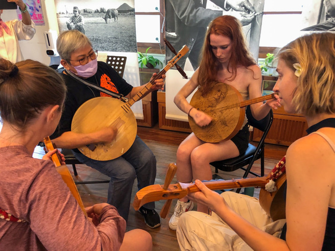 来自世界各国的孩子到恒春找阿嬷学月琴。(图取自周春米脸书)