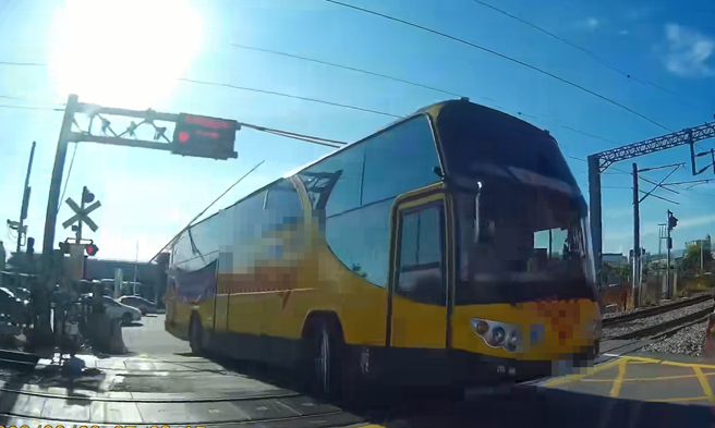 平交道铃声响起，栅栏缓缓放下时，当地一间私立中学的校车疑似为抢快竟强行通过，导致栅栏当场撞上车顶，触发列车防护系统。（翻摄自脸书「爆料公社」）