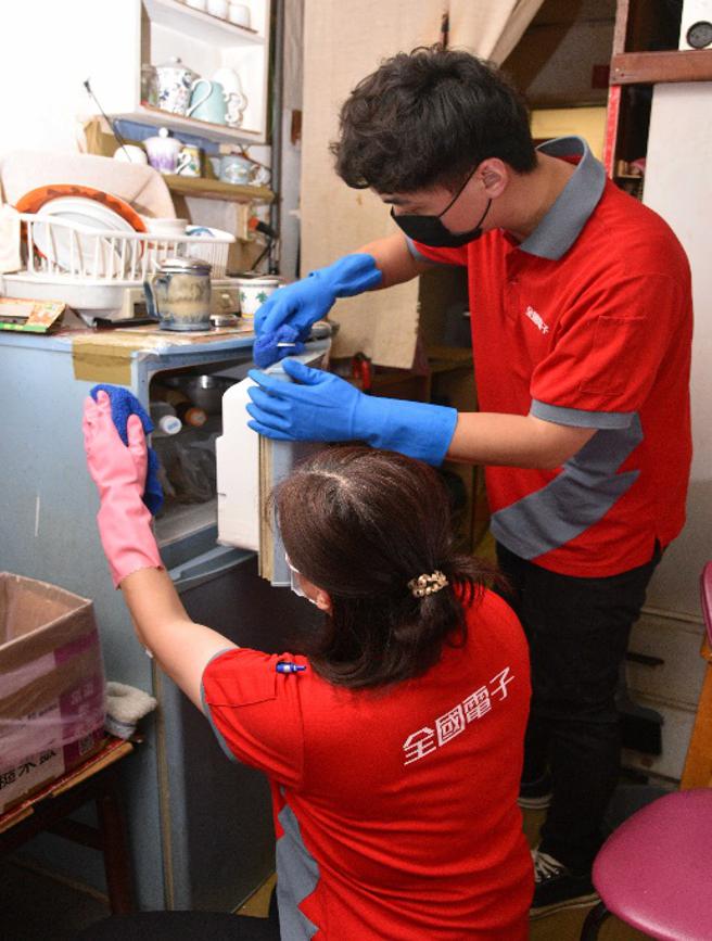 全国电子员工协助弱势长辈清洁和检视冰箱。（全国电子提供）