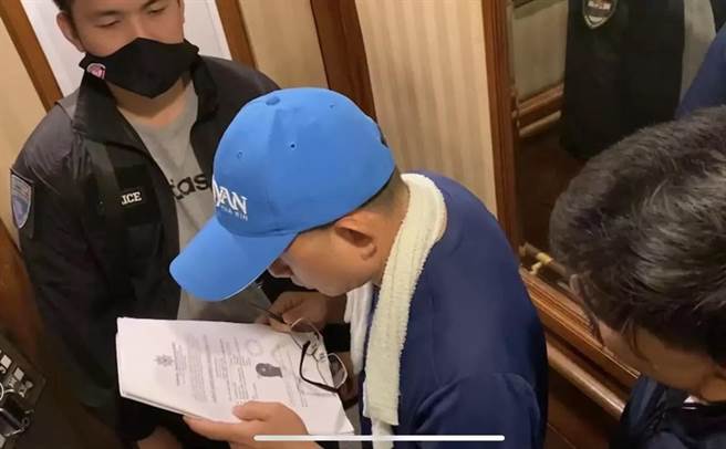 警方到黃嫌住處要將他逮捕時，黃嫌還先仔細檢視資料。（翻攝照片／林郁平台北傳真）