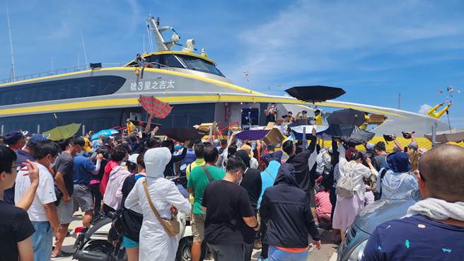 船家依循传统掷吉给岸边民眾，分享喜悦。（许逸民摄）