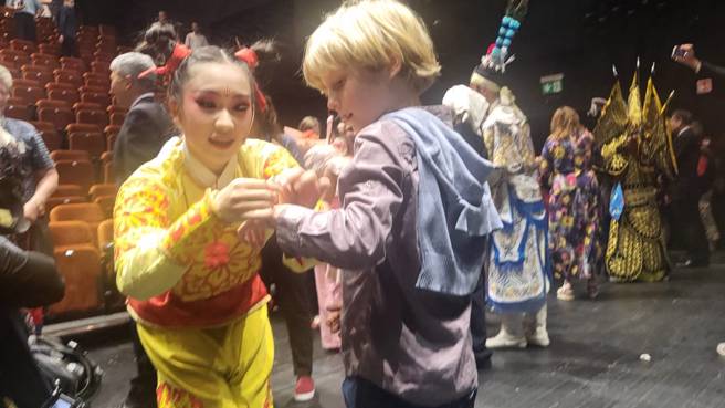 紙風車劇團赴布達佩斯演出《哪吒鬧龍宮》，於當地時間20日晚間首演完畢，劇中守護小朋友的神祉角色孩子仙哪吒，也受到熱烈歡迎，許多小朋友前來和她擁抱致意。（李欣恬攝）