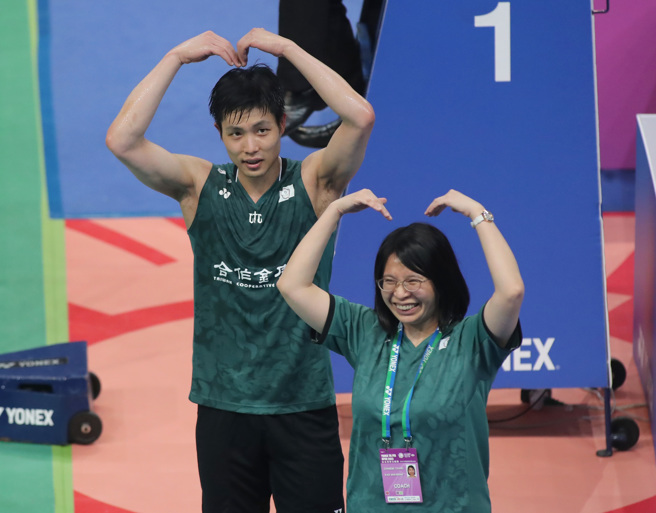 周天成（左）和物理治疗师高敏珊（右）对球迷比出爱心手势。（郑任南摄）