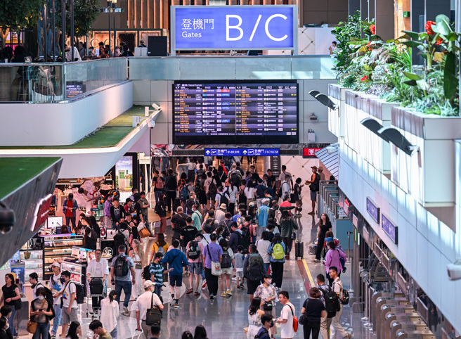 端午节连续假期第一天，桃园机场涌现出国旅游人潮，22日当日的出入境预报量逾11万人次，不少旅客都是携家带眷全家出动，趁着端午连假开启疫后久违的出国旅游。（陈麒全摄）