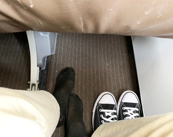 國外一名男子搭飛機時，遇到後座女乘客脫鞋，還把腳從座位下伸出，讓他忍無可忍，拿飲料滴在對方的腳上。(示意圖/達志影像)