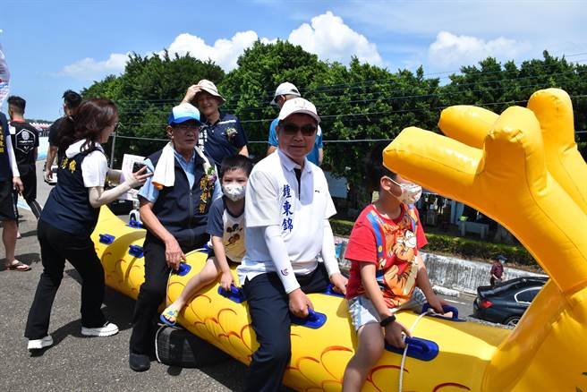 苗栗县竹南镇2023年龙舟锦标赛22日端午节在中港溪登场，苗栗县长锺东锦与小朋友一起跨坐小龙舟上。（谢明俊摄）