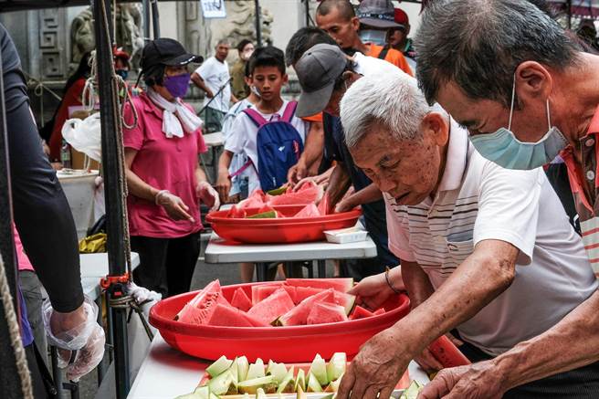 新竹县县长杯龙舟竞赛，现场民眾大排长龙免费品尝西瓜和洋香瓜。（罗浚滨摄）