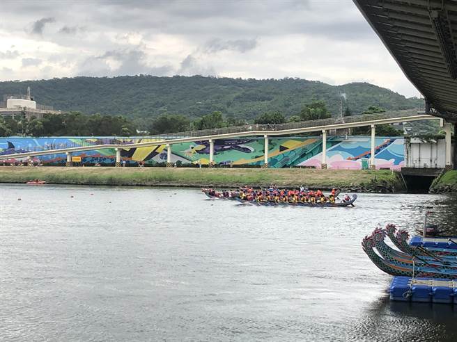 表演赛在岸边人潮加油声中开跑，4组人马都奋力向前划。（张芷瑜摄）