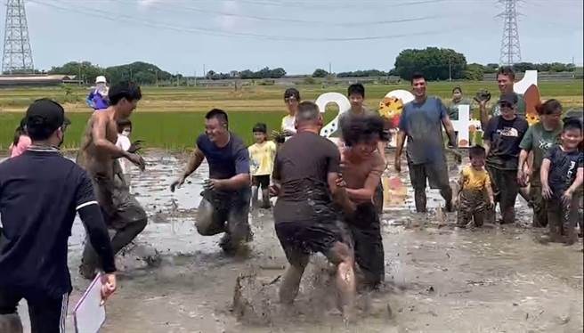 稻田运动会参赛者在泥田中捉对厮杀，每个都摔得全身都是泥，尖叫声不比笑声小，小朋友玩得最嗨。（周丽兰摄）