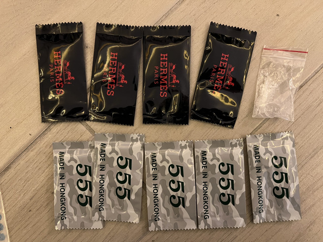 警方在床底下发现一红包袋内放有9包爱马仕毒咖啡包。（图／警方提供）