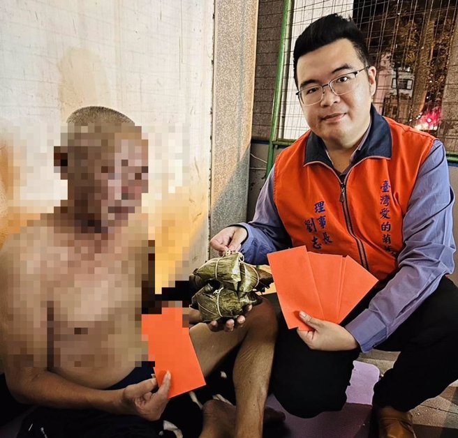 台湾爱的萌芽福利协会理事长刘志枰（右）在端午连假致赠粽子、红包给街友。（协会提供）