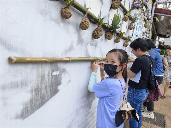 流域行动艺术祭24日开幕，艺术家李意婕以参与式创作「栖地」，和民眾一起以虎尾兰等植物完成作品。（赖佑维摄）