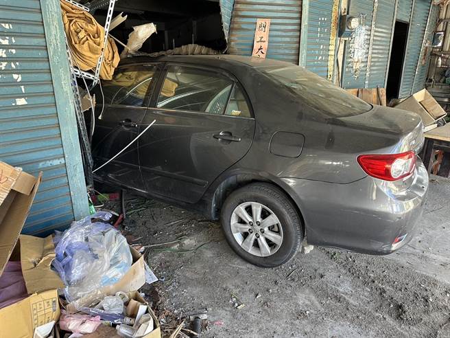 1辆黑灰色小轿车以近乎90度的角度，衝撞进路边1户民宅，猛烈的撞击力道，把民宅蓝色铁卷门撞破。（台东县警察局提供／萧嘉蕙台东传真）