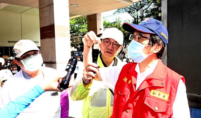 预防登革热，高雄市副市长林钦荣（前右）27日到冈山区工地视察，他查看採样瓶内的孑孓。（林瑞益摄）