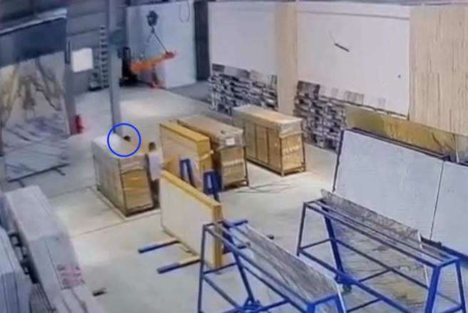 高雄燕巢区一家大理石材工厂27日下午发生工安意外，一名工人（蓝圈处）在清点石材时被倒下的石材压中昏迷，送医不治。（翻摄照片／林瑞益高雄传真）