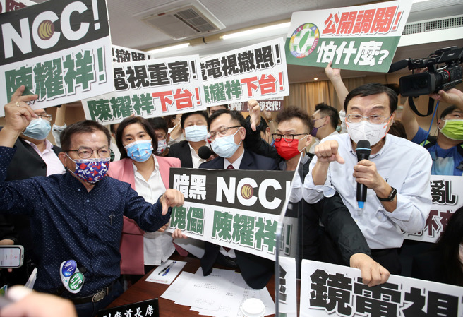 图为立法院交通委员会去年10月5日邀NCC主委陈耀祥（中）专案报告并备询，国民党立委举出标语包围陈，并高喊「镜电视撤照、陈耀祥下台」。（资料照,姚志平摄）