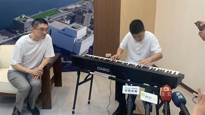 ▲张闻竺同学（右）2岁时被诊断患有自闭症、过动症、感觉统合失调等多重身心障碍疾病，但仍克服万难，努力向学。图为闻竺现场弹奏名曲「卡农」，基隆市长谢国梁（左）在旁聆听，相当动人。（徐佑升摄）