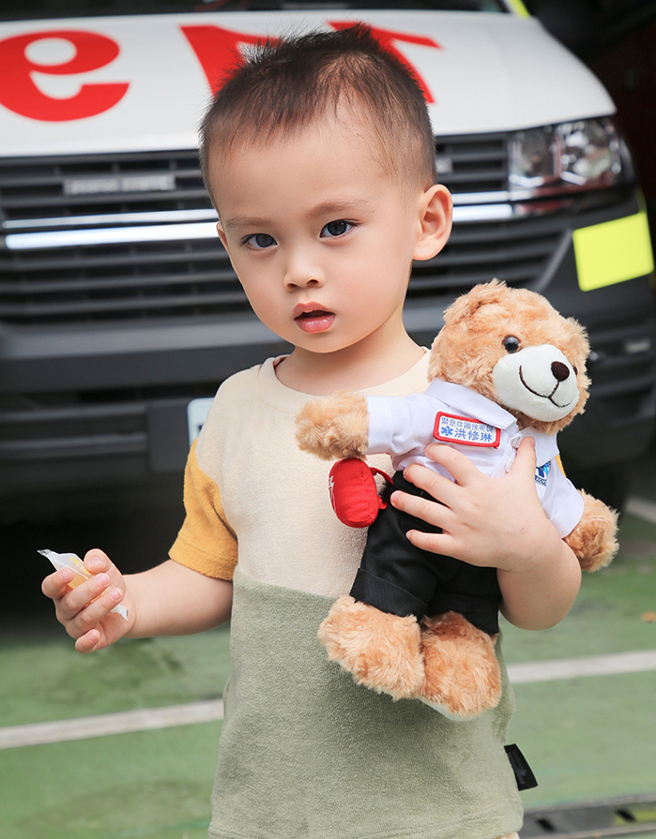 老二泰迪手上抱著有媽媽名牌的消防員熊，很以媽媽的職業為傲。(圖/ 嬰兒與母親提供）