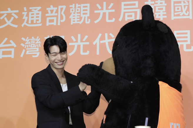 魏嘏雋與觀光局吉祥物「喔熊組長」互動逗趣。（孫伊萱攝）