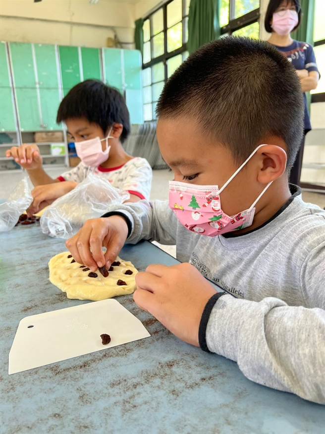 羅娜國小學童在台灣四位天王級麵包師傅手把手傳授下，裝飾麵包。（民眾提供／楊靜茹南投傳真）
