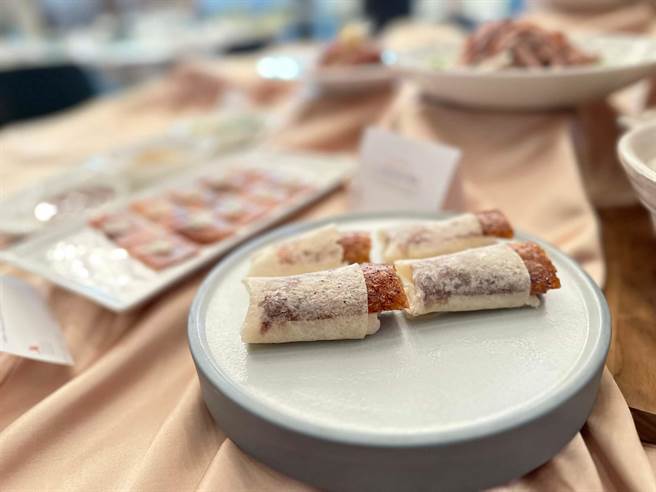 第一吃「青瓜季葱鸭卷饼」，烤鸭师傅陈吉南展现精细刀工，将片皮鸭的厚度维持0.2公分，油亮的鸭皮贴合半透明的丰腴鸭油，裹上秘制甜麵酱包入手擀饼皮中，放上四季葱段与青瓜，入口酥香油润。（柯宗纬摄）