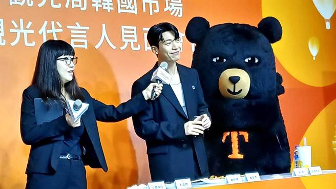 魏嘏隽和台湾观光局「喔熊组长」猜拳互动，猜输了挑战喝苦茶。（陈韵萍摄）