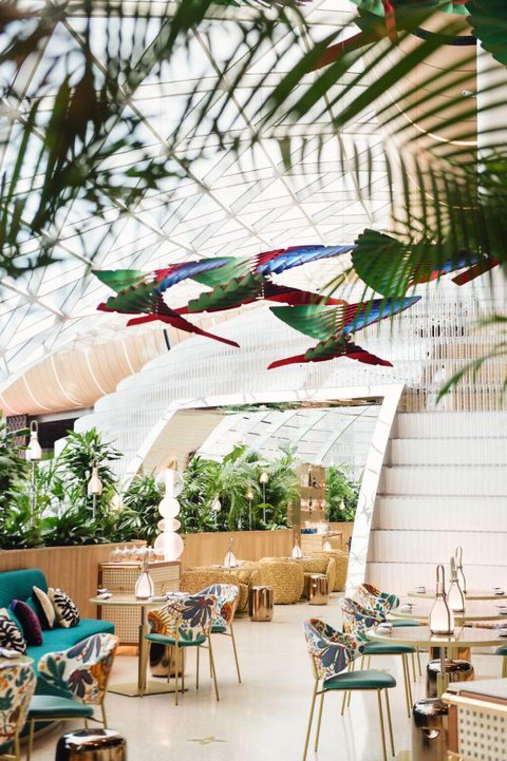 天花板懸吊瑞士設計三人組 Atelier Oï 創作的雕塑，以南美魁札爾鳥羽翼為創作靈感。（圖／Louis Vuitton）