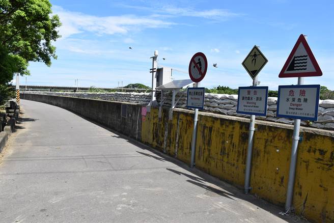 头份市尖山里米粉街中港溪堤防现已迭上沙包应变。（谢明俊摄）