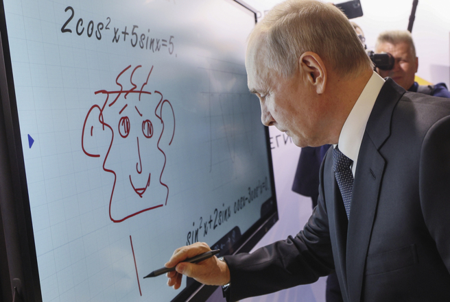 俄罗斯总统普丁6月29日在莫斯科参观本国知名品牌展时，在多媒体白板上画了一张脸并签名。（美联社）